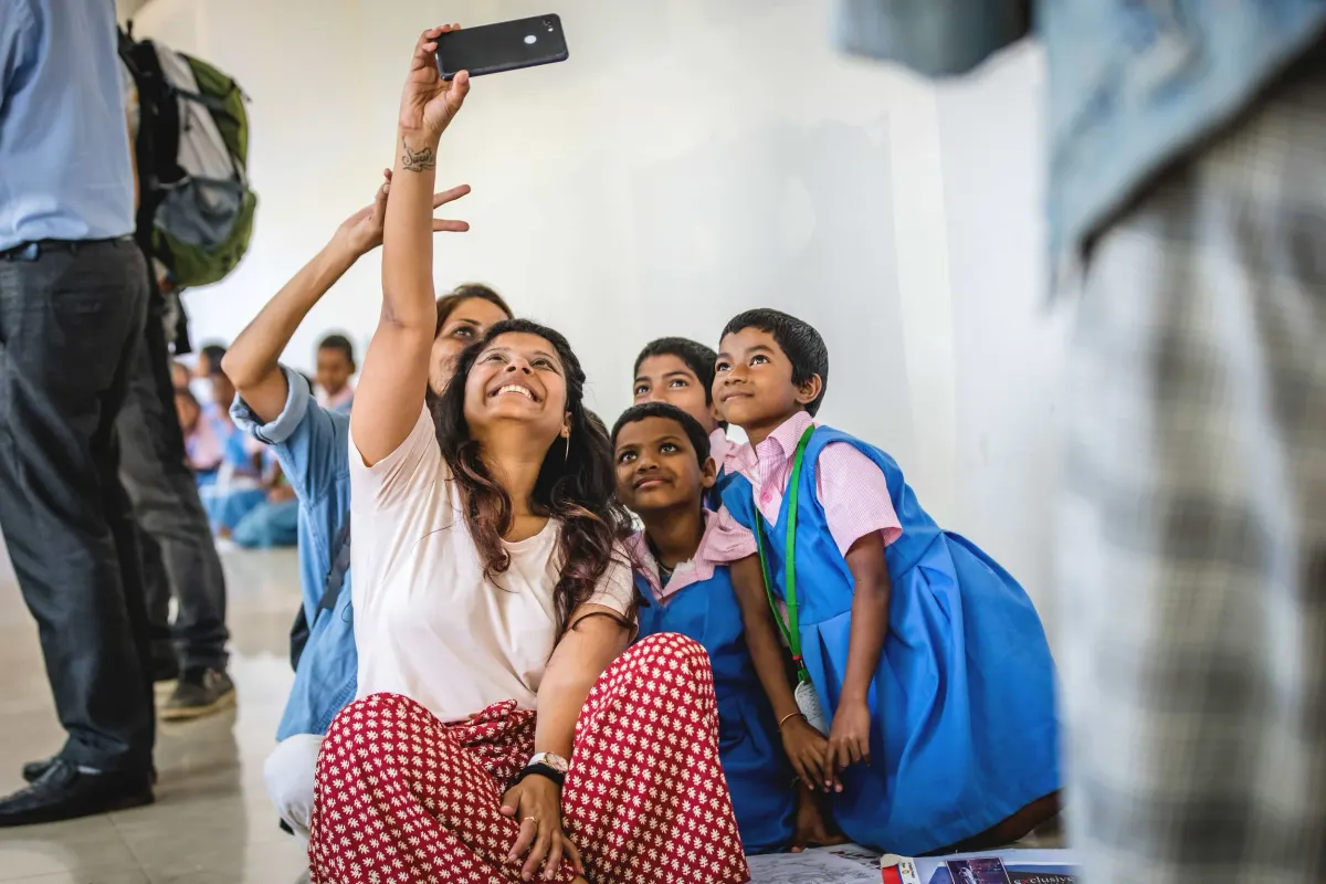 A creator taking a selfie with students at KISS, Odisha