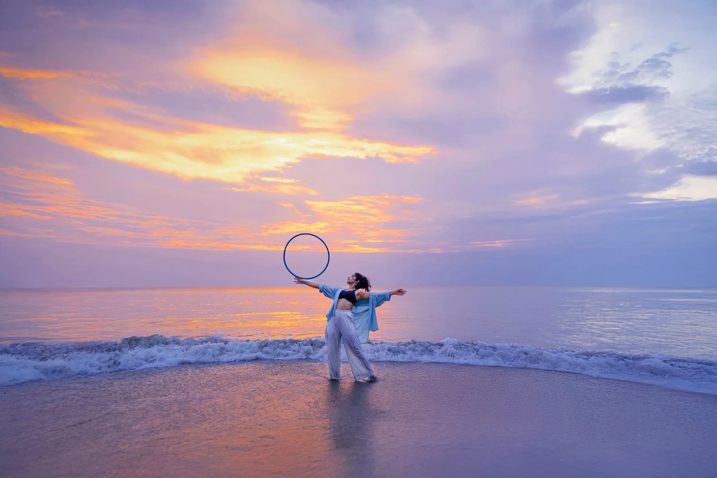 Eshna Kutty hooping on the shore at sunset