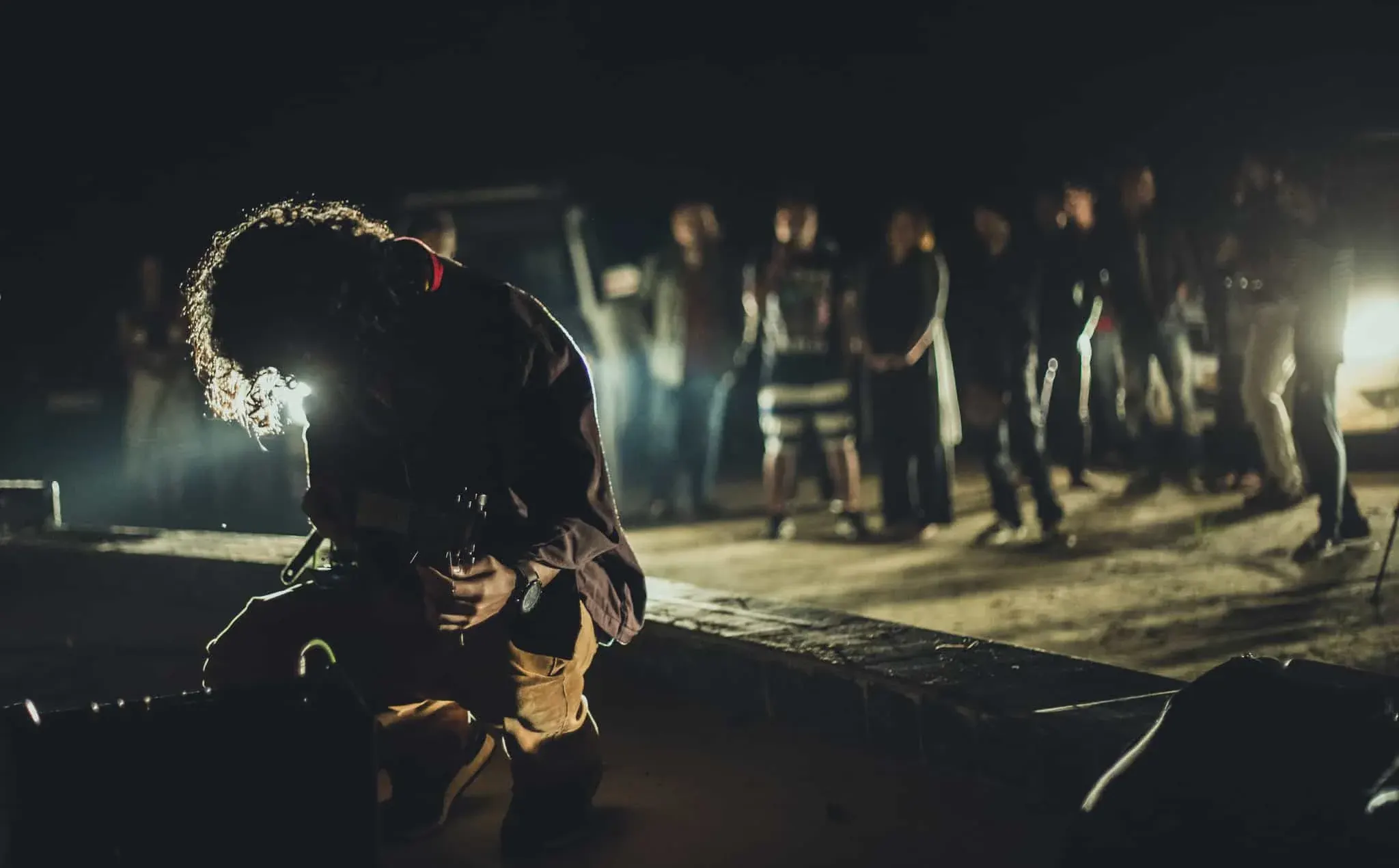 A performer mid-set on a riverside stage at night, with the crowd gathered close in the dark