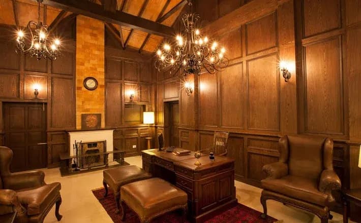 A wood-panelled sitting room with a chandelier at Old Kent Estate, Coorg